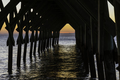 Pier over sea against sky during sunset