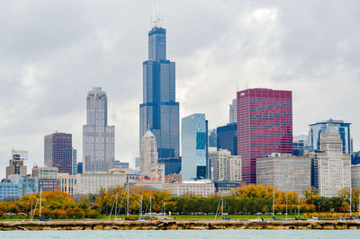 Skyscrapers in city against cloudy sky