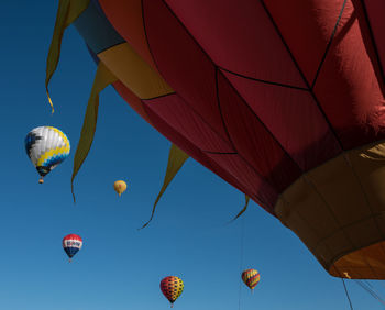 Low angle view of hot air balloons flying in clear sky