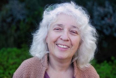 Portrait of a smiling gray-haired curly woman. looking straight into the camera.