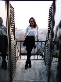 Portrait of smiling young woman standing on floor