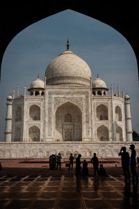 People in front of taj mahal against sky