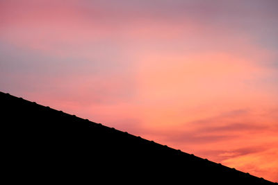 Low angle view of silhouette mountain against dramatic sky