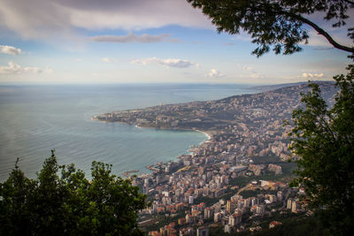 High angle view of townscape by sea against sky