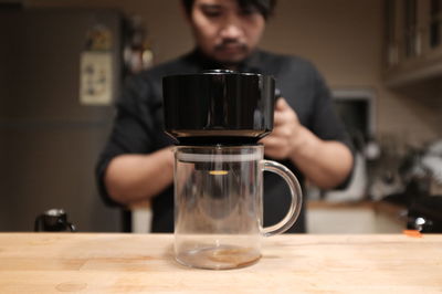 Man holding drink in glass on table