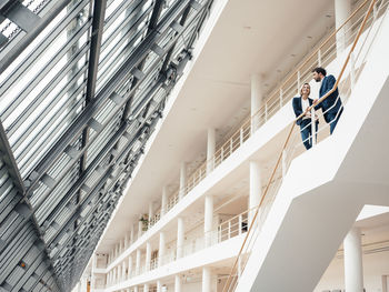 Male and female entrepreneur having discussion while standing in staircase