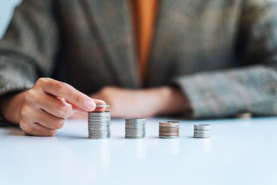 Midsection of man holding coin against white background