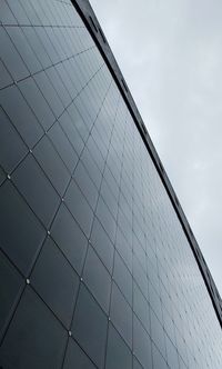 Low angle view of glass building against sky