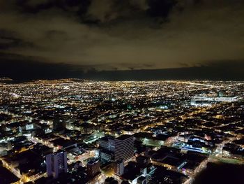 Aerial view of illuminated cityscape against sky at night