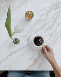 High angle view of hand holding drink on table