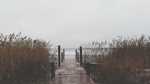 Wooden pier amidst sea against sky