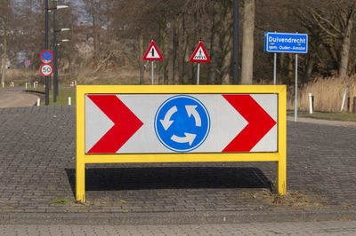 Information sign on road against wall