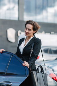 Young woman looking down while standing on car