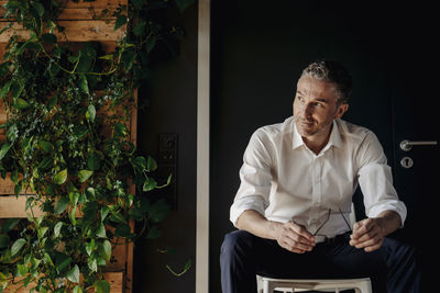 Businessman sitting in green office thinking