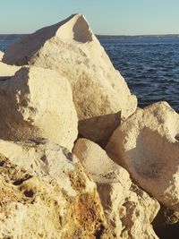 Scenic view of rocks on beach against sky