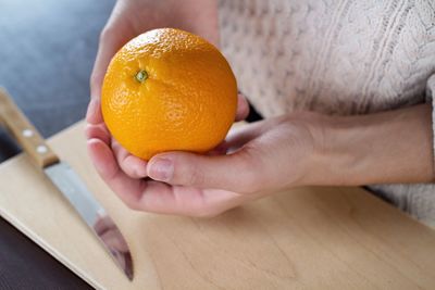 Cropped image of hand holding orange slice