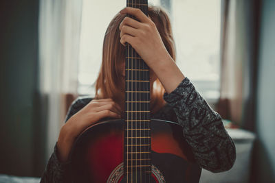 Midsection of man playing guitar