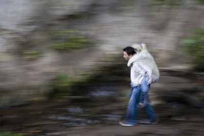 Blurred motion of man walking on road