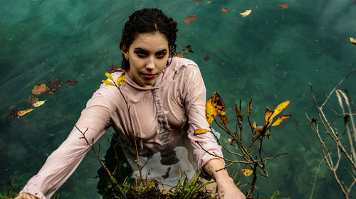 Young woman with flowers in lake