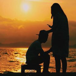 Silhouette of woman standing at sunset