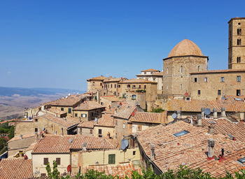 Houses in city against clear blue sky