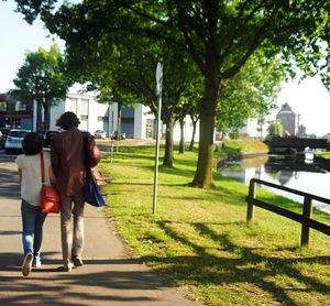 Rear view of friends walking on road