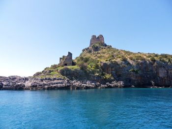 Built structure by sea against clear sky