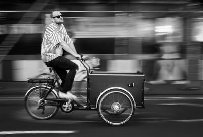 Man riding bicycle on road in city