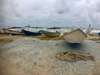 Boats moored on beach against sky