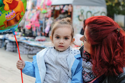 Portrait of girl with mother at amusement park