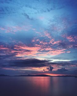 Scenic view of sea against dramatic sky during sunset