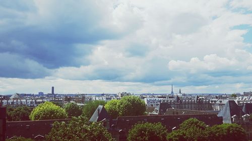 View of cityscape against cloudy sky