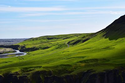 Scenic view of green landscape against sky