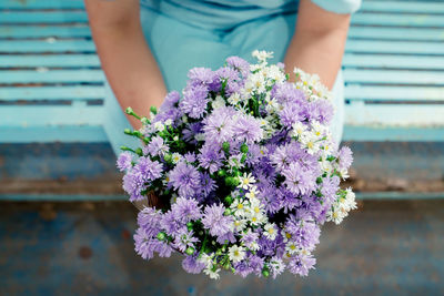 Midsection of woman holding flower bouquet