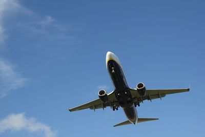 Low angle view of airplane against clear blue sky