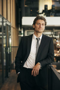 Portrait of young man standing in cafe