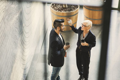 High angle view of businesswoman explaining coworker at office