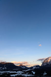 Scenic view of snowcapped mountains against blue sky during sunset