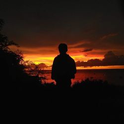 Silhouette of man looking at sunset