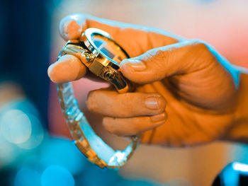 Close-up of hand holding wristwatch