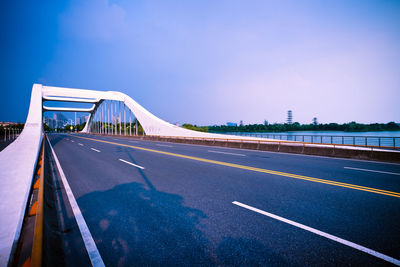 View of bridge over road against blue sky