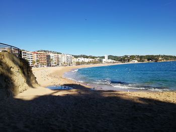 Scenic view of beach against clear blue sky