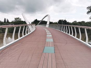 View of footbridge against cloudy sky