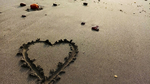 High angle view of heart shape on sand at beach