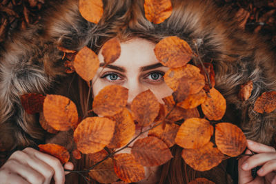 Close-up of human hand holding autumn leaves