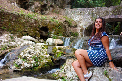 Young woman sitting on rock