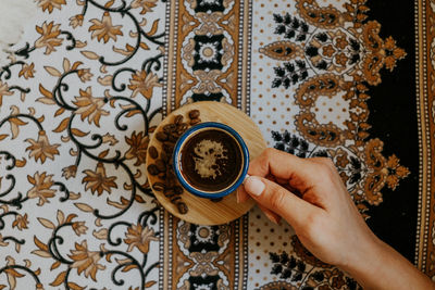 Low section of person holding coffee cup