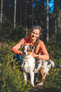 Candid portrait of female athlete with her running and hiking partner, an australian shepherd dog