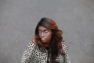 Young woman with eye make-up on road