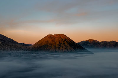 Scenic view of snowcapped mountain against sky during sunset